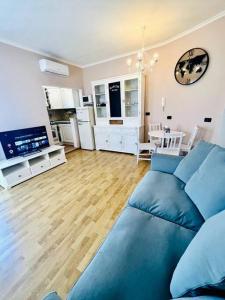 a living room with a blue couch and a kitchen at Civico 22 in Fiumicino