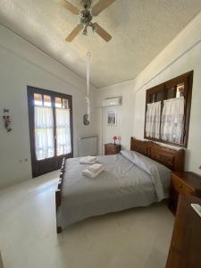 Un dormitorio con una cama y un ventilador de techo. en Thalatta and Oros Traditional Villa, en Tyros