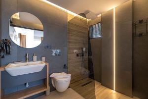 Un baño con lavabo, inodoro y espejo. en luxurylifevillas 1-2-3-4, en Fethiye 29 fotos más