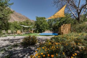 a kite flying over a garden with chairs and flowers at Cabaña Jacuzzi Exterior Privado in San José de Maipo