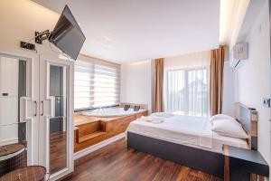 1 dormitorio con bañera, 1 cama y TV en luxurylifevillas 1-2-3-4, en Fethiye