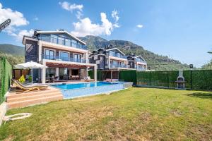 a large house with a swimming pool in a yard at luxurylifevillas 1-2-3-4 in Fethiye