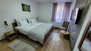 - une chambre avec un lit et une télévision dans l'établissement Plitvica Villa Prica, aux lacs de Plitvice