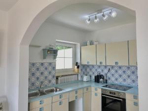 a kitchen with blue and white tiles and a sink at Ferienwohnung Lusenhöh in Mauth