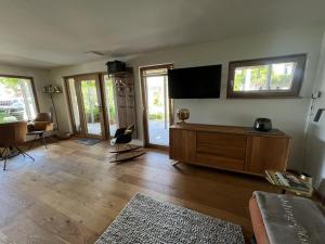 a living room with a flat screen tv on the wall at kleine Schwarzwaldlodge in Efringen-Kirchen