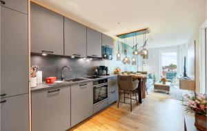 una cocina con armarios blancos y una mesa. en 1 Bedroom Nice Apartment In Nordstrand, en Nordstrand