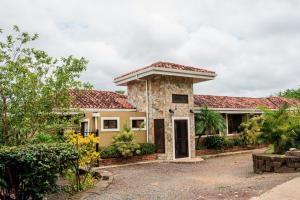 una casa de piedra con techo rojo en Exquisite Private Coastal Retreat home en San Juan del Sur