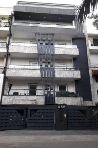 a black and white building with a gate in front of it at Mintstar Apartment and Suites, East of Kailash in New Delhi