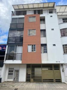 un grand bâtiment avec des fenêtres et des portes. dans l'établissement Apartamento bien ubicado., à Bucaramanga