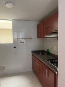 a kitchen with wooden cabinets and a counter top at Apartamento bien ubicado. in Bucaramanga