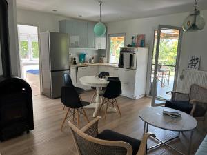 a kitchen and living room with a table and chairs at Kisvirág Vendégház in Balatonvilágos