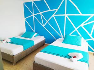 2 letti in una camera con pareti blu di APT con vista al Mar - Cerca al Centro Histórico - 1106 a Cartagena de Indias