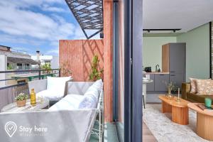 - un balcon avec des chaises et une table dans un bâtiment dans l'établissement Stayhere Casablanca - Maarif - Elite Residence, à Casablanca