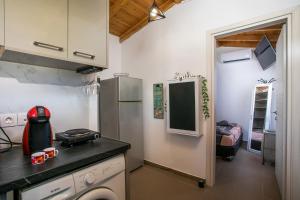 a small kitchen with a stove and a refrigerator at Marco Beach Tiny House in Faliraki