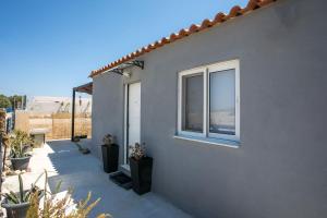 ein Haus mit einem Fenster an der Seite in der Unterkunft Marco Beach Tiny House in Faliraki