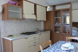 una cucina con lavandino e piano cottura forno superiore di Appartamento Stella Marina a Marcelli