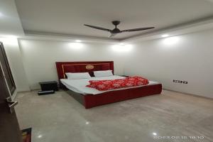 a bedroom with a bed with red sheets and a ceiling at Mintstar Apartment and Suites, East of Kailash in New Delhi