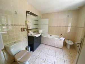 uma casa de banho com um WC, um lavatório e uma banheira em Les Moulins Du Duc ÉCOLODGE em Moëlan-sur-Mer