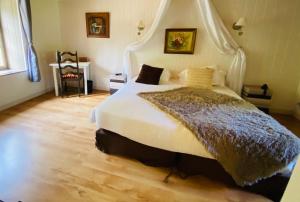 sypialnia z dużym białym łóżkiem z baldachimem w obiekcie Les Moulins Du Duc ÉCOLODGE w mieście Moëlan-sur-Mer