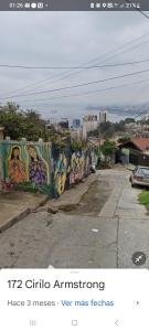 een muur met graffiti naast een straat bij Casa en Valparaíso con vista al mar in Valparaíso