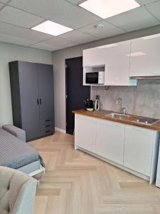 uma cozinha com armários brancos e um lavatório num quarto em Mooie studio 14 Cn in center em Roterdã