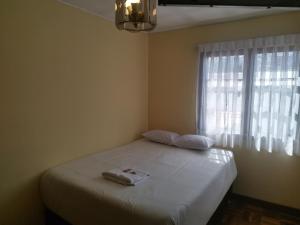 a bedroom with a white bed with a window at Hotel RustiCall in La Paz