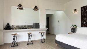 a bedroom with a bed and a kitchen at Aguas Claras Luxury Hospedaje in Filandia