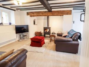 a living room with leather furniture and a fireplace at Cae Gogrydd in Machynlleth