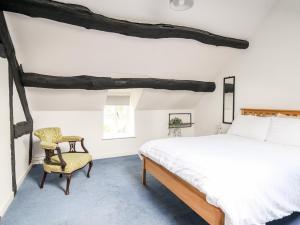 a bedroom with a bed and a chair at Cae Gogrydd in Machynlleth