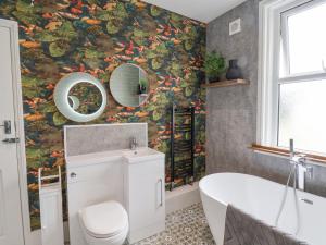 a bathroom with a toilet and a wall mural at 3 Auborough Street in Scarborough