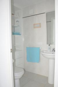 a white bathroom with a toilet and a sink at Pianc in Cadaqués