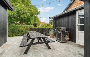 a picnic table and a grill on a patio at 3 Bedroom Lovely Home In Sams in Ballen