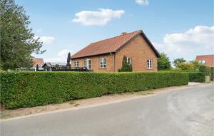 a brick house with a hedge in front of a street at 3 Bedroom Lovely Home In Sams in Ballen