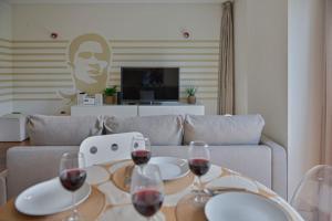 una sala de estar con una mesa con copas de vino en Ola Lisbon - Benfica, en Lisboa