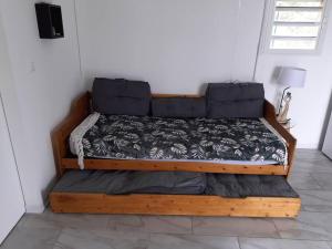 uma cama de madeira num quarto com em Bungalow agéable et confortable, parking securisé em Vieux-Habitants