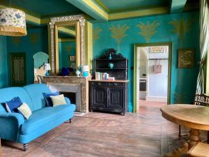 sala de estar con sofá azul y chimenea en Gogascony en Lavit