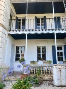 Casa blanca con balcón y flores púrpuras en Gogascony en Lavit