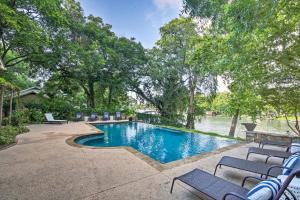 una piscina con sedie accanto a un bacino d'acqua di Guadalupe River Paradise with Hot Tub, Dock and Kayaks a Seguin