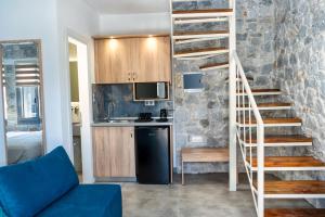 a living room with a spiral staircase and a kitchen at THALASSIA LUXURY APARTMENTS in Stavros