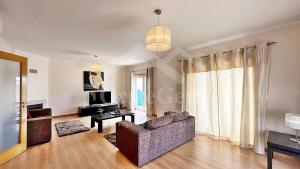 Una sala de estar con un sofá y un televisor. en Santa Efigênia, en Lourinhã