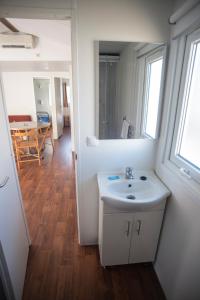 bagno con lavandino, specchio e tavolo di Parque de Campismo Orbitur Foz de Arelho. a Foz do Arelho