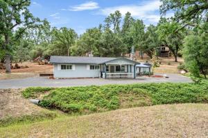 a small white house with a driveway at Sweet Haven - Home with EV Charger near Yosemite in Groveland