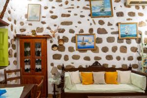 a living room with a couch and a wall with pictures at Vintage White House Patmos in Patmos