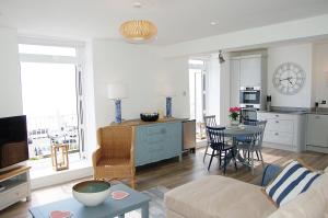 a living room with a couch and a table at Driftwood Designer Apartment in Tywyn
