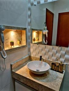 uma casa de banho com um lavatório e um espelho em Villa dos Diamantes - 14 em Porto Seguro