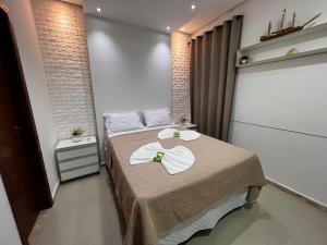 um quarto com uma cama com duas toalhas em Villa dos Diamantes - 14 em Porto Seguro