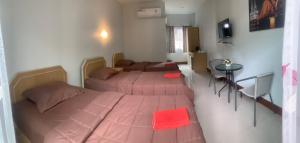 - une chambre avec 2 lits et une table dans l'établissement บ้านพักณัฐรินีย์, à Sam Phran