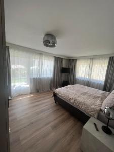 a bedroom with a bed and wooden floors and windows at Bergerwachen in Berchtesgaden