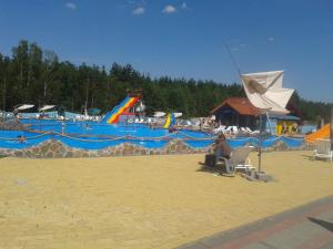 a person sitting in a chair near a swimming pool at Kaszuby Dom W Wielu in Wiele