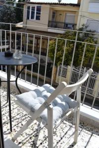 une chaise blanche assise à côté d'une table sur un balcon dans l'établissement Ba & Bu Apartment 1, à Kateríni